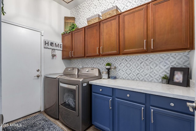 laundry area featuring washer and clothes dryer and cabinets