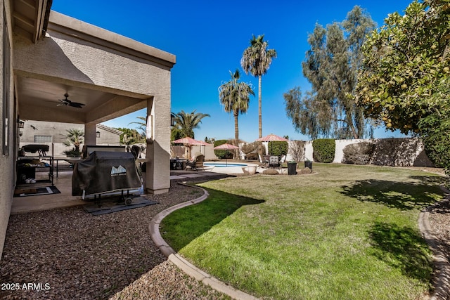 view of yard with a fenced in pool, a patio area, and ceiling fan