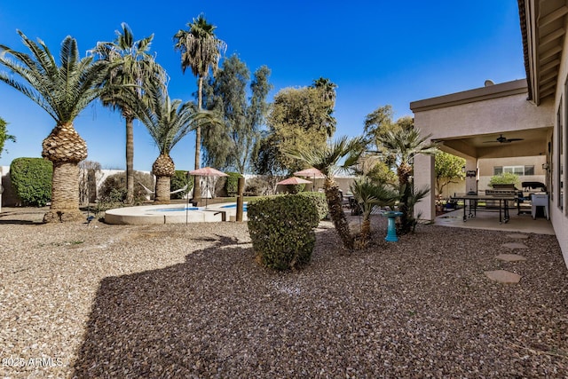 view of yard featuring ceiling fan and a patio area