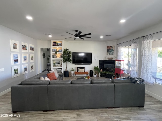 living room with ceiling fan and light hardwood / wood-style floors