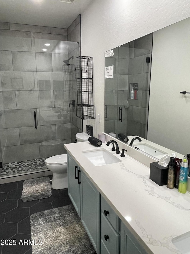 bathroom with tile patterned floors, vanity, toilet, and an enclosed shower