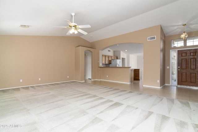 unfurnished living room featuring lofted ceiling, ceiling fan with notable chandelier, and light colored carpet