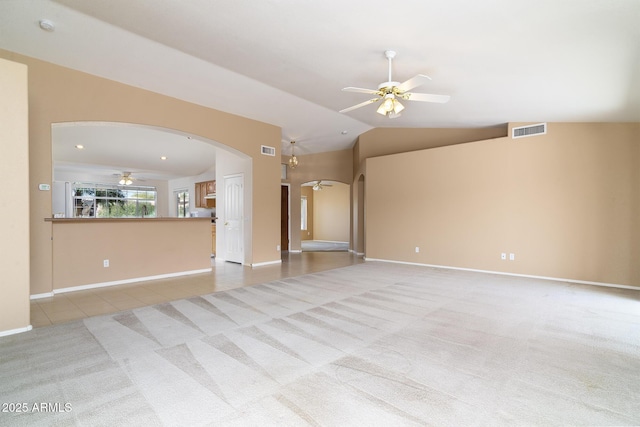 unfurnished living room with vaulted ceiling, light colored carpet, and ceiling fan