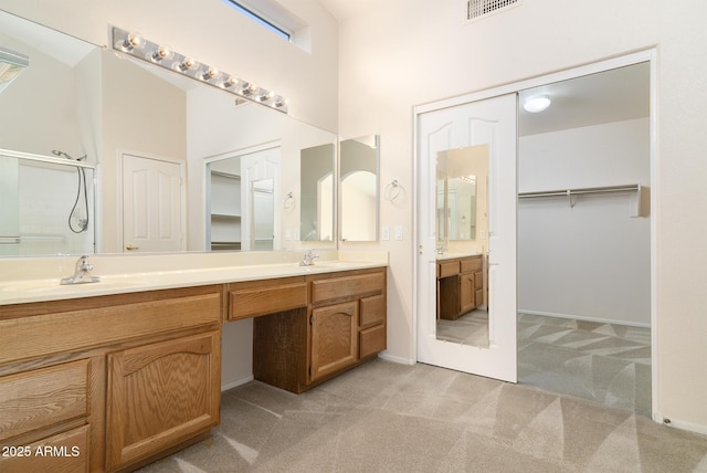 bathroom with vanity, a shower with door, and a high ceiling