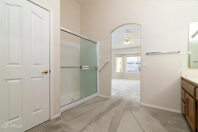 bathroom with walk in shower, ceiling fan, and vanity