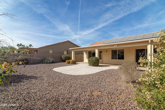 rear view of property with a patio and solar panels