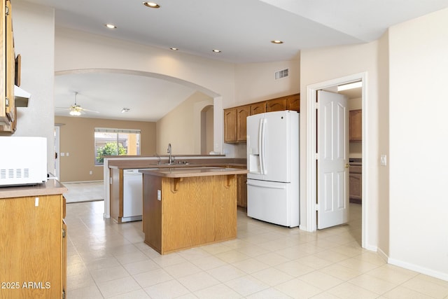 kitchen featuring lofted ceiling, sink, white appliances, ceiling fan, and a center island