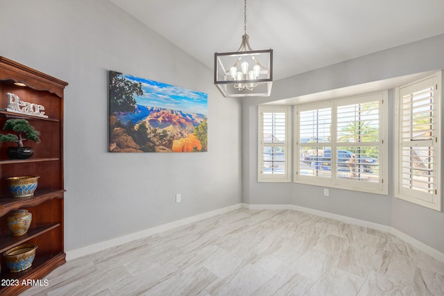 spare room with lofted ceiling and a chandelier