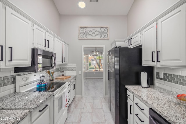 kitchen featuring plenty of natural light, stainless steel appliances, light stone counters, and white cabinetry