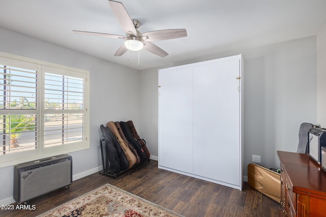 interior space featuring a wall mounted AC, dark wood-type flooring, and ceiling fan