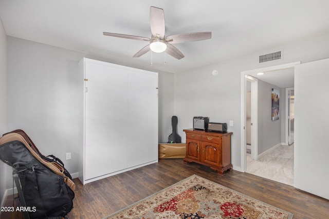 interior space featuring dark wood-type flooring and ceiling fan