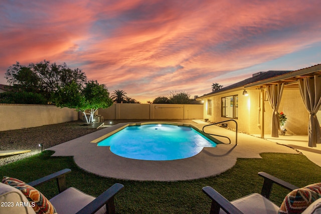 pool at dusk featuring a patio