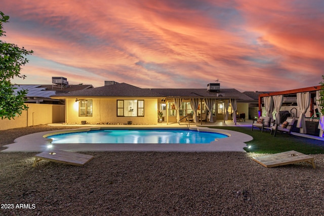 pool at dusk featuring a patio