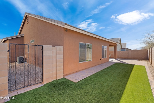 view of side of property featuring central AC, a yard, and a patio