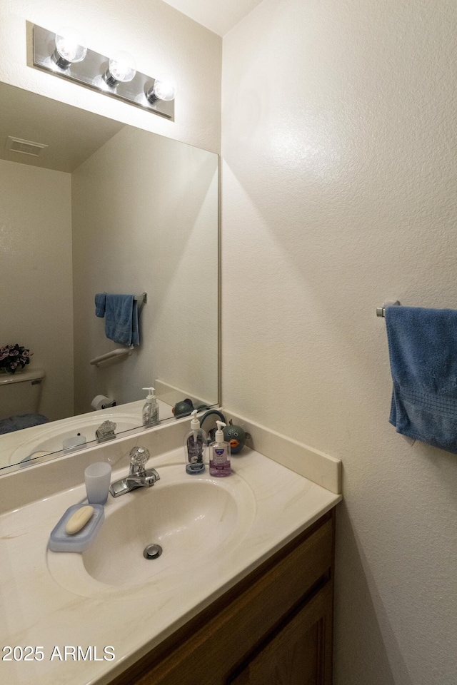 bathroom featuring vanity and toilet