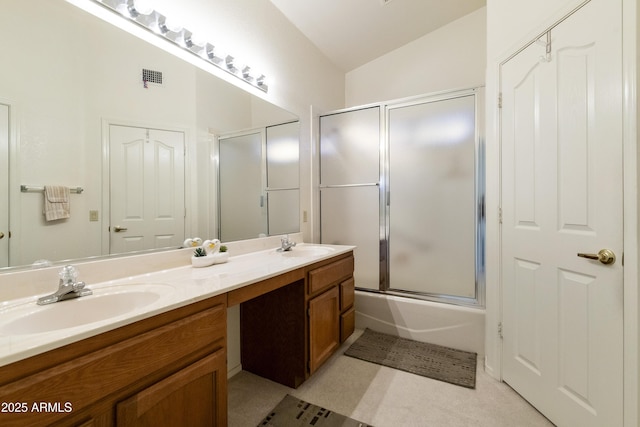 bathroom with vanity, combined bath / shower with glass door, and vaulted ceiling