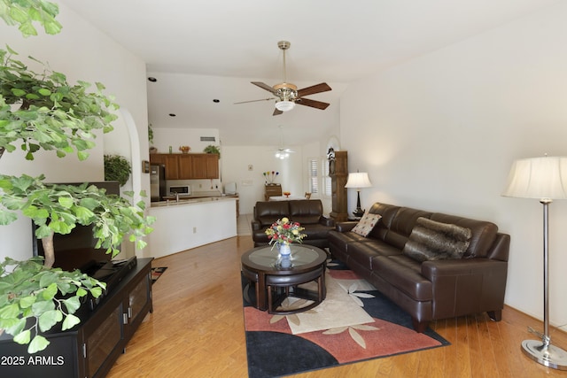 living room featuring vaulted ceiling, sink, ceiling fan, and light hardwood / wood-style flooring