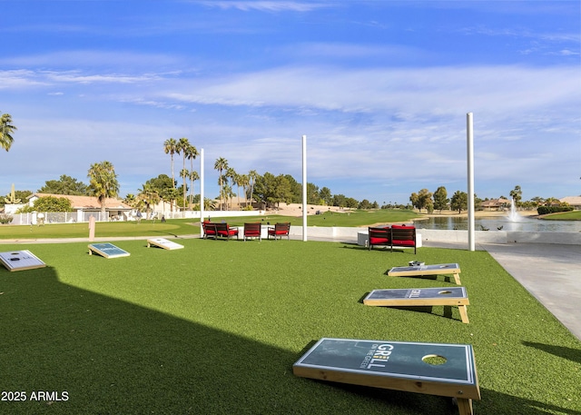 view of property's community with a water view and a yard