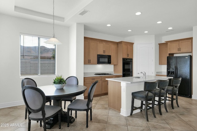 7917 S 32nd Ter, Phoenix, AZ 85042 - kitchen featuring sink, a center island with sink, a tray ceiling, pendant lighting, and black appliances