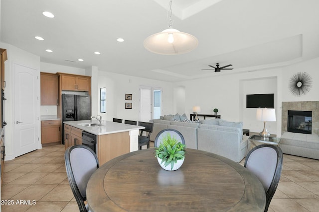 7917 S 32nd Ter, Phoenix, AZ 85042 - tiled dining area featuring sink, a tray ceiling, a fireplace, and ceiling fan