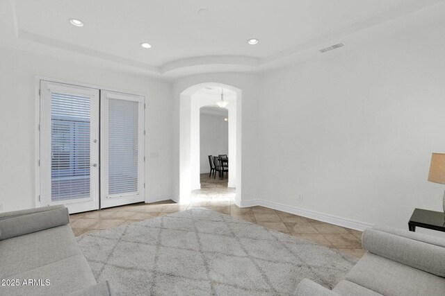 7917 S 32nd Ter, Phoenix, AZ 85042 - unfurnished living room with light tile patterned flooring and a tray ceiling