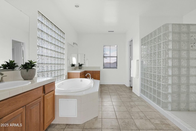 7917 S 32nd Ter, Phoenix, AZ 85042 - bathroom featuring vanity, tile patterned flooring, and a relaxing tiled tub