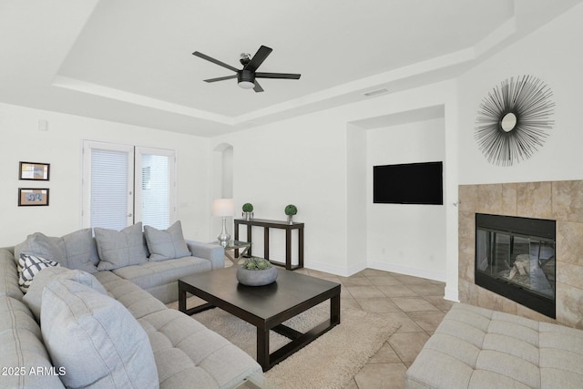 7917 S 32nd Ter, Phoenix, AZ 85042 - tiled living room featuring ceiling fan, a fireplace, and a tray ceiling
