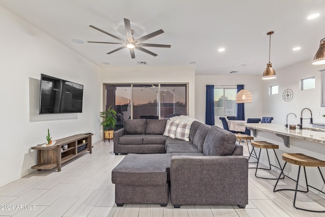 living room with ceiling fan and sink