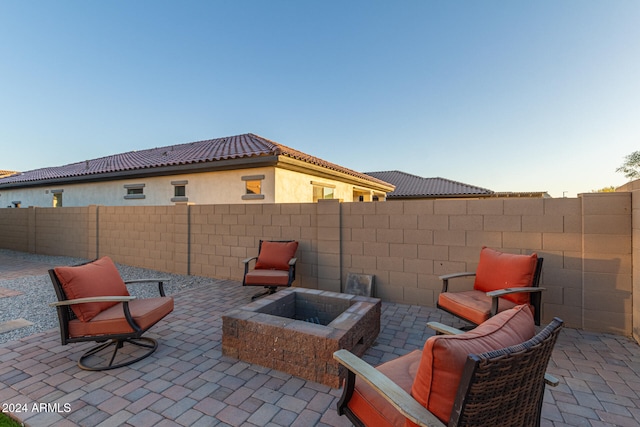 patio terrace at dusk featuring an outdoor fire pit