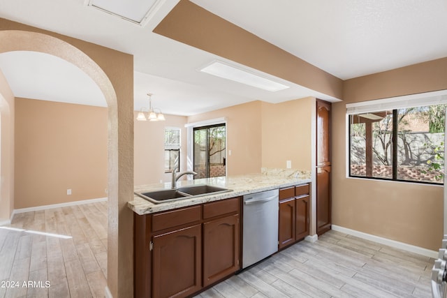 kitchen featuring light hardwood / wood-style floors, an inviting chandelier, sink, stainless steel dishwasher, and pendant lighting