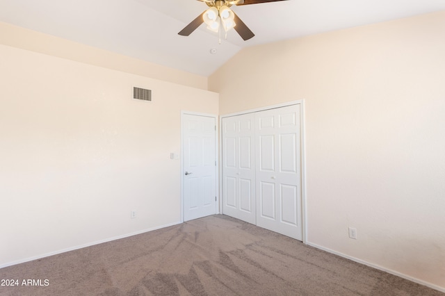 unfurnished bedroom with a closet, vaulted ceiling, light colored carpet, and ceiling fan