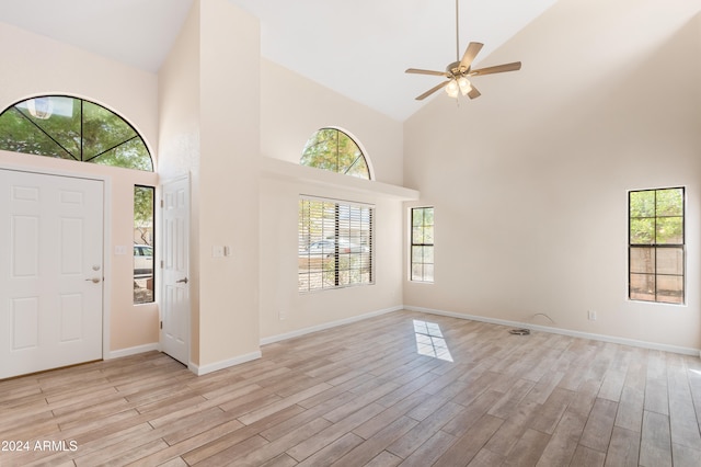 foyer entrance with ceiling fan, light hardwood / wood-style flooring, and high vaulted ceiling