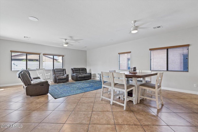 dining space with light tile patterned floors, visible vents, and ceiling fan