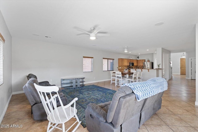 living area featuring light tile patterned floors, baseboards, visible vents, and ceiling fan