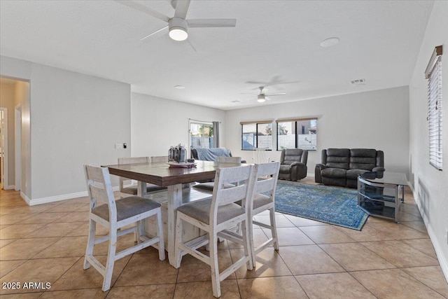 dining room with light tile patterned floors, visible vents, baseboards, and a ceiling fan