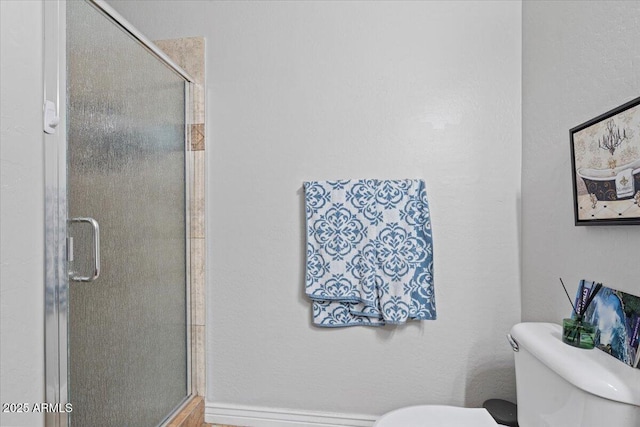 bathroom featuring toilet and a shower stall