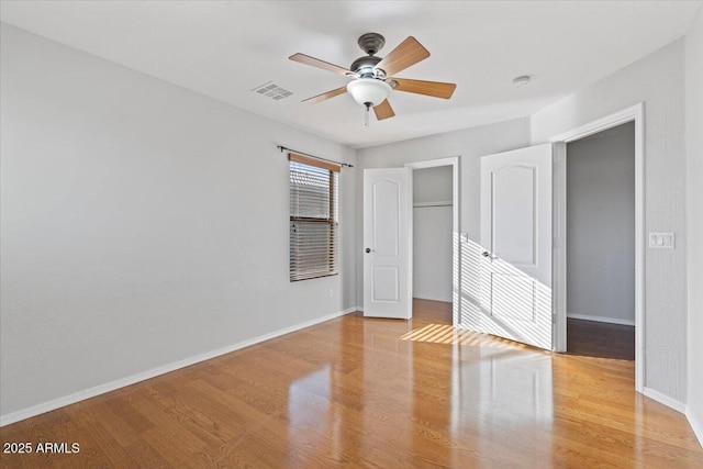 unfurnished bedroom featuring baseboards, visible vents, a closet, and light wood-type flooring