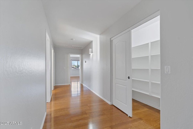 hallway featuring baseboards and wood finished floors