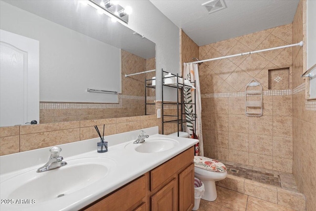 full bath featuring visible vents, tiled shower, toilet, and a sink