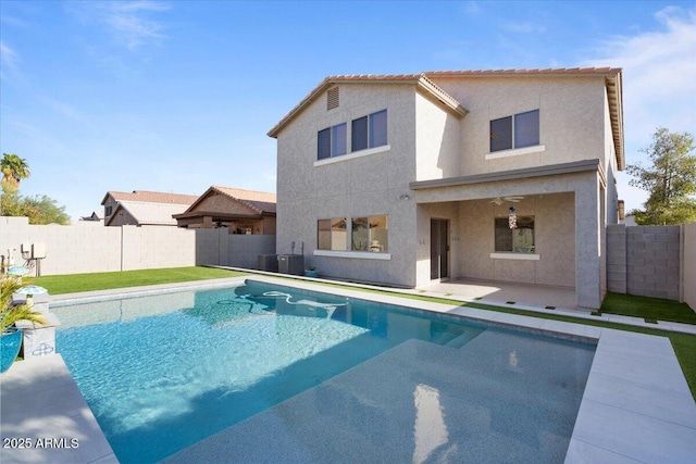 rear view of property with a patio area, a fenced backyard, a fenced in pool, and stucco siding