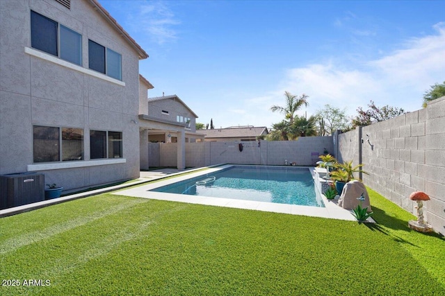 view of swimming pool with a lawn, central AC unit, and a fenced backyard