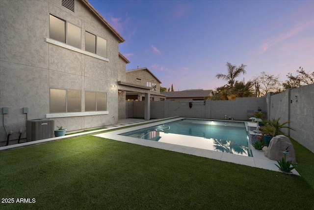 pool at dusk with a fenced backyard, a yard, central AC, and a fenced in pool