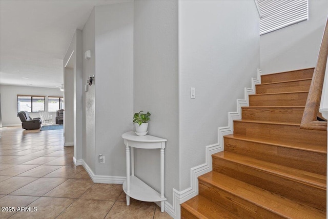 stairway featuring tile patterned floors and baseboards