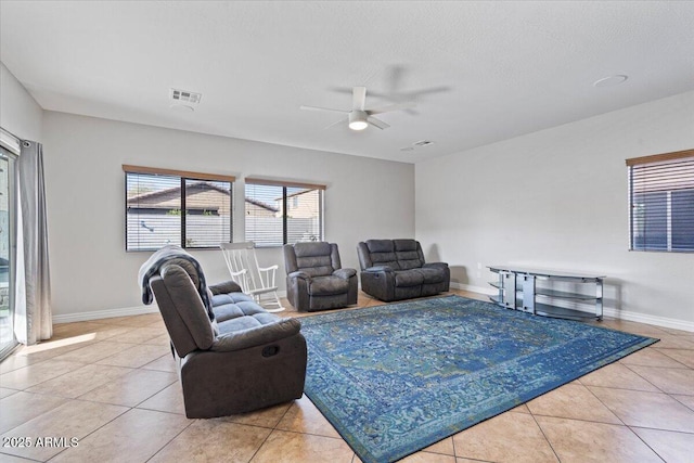 living area featuring light tile patterned floors, visible vents, and baseboards