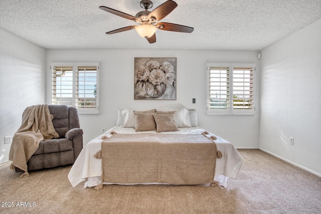 bedroom with ceiling fan, a textured ceiling, light carpet, and multiple windows