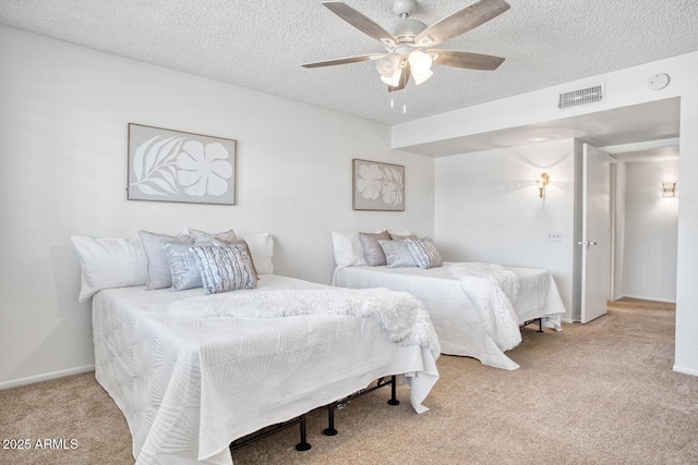 bedroom featuring ceiling fan, light colored carpet, and a textured ceiling