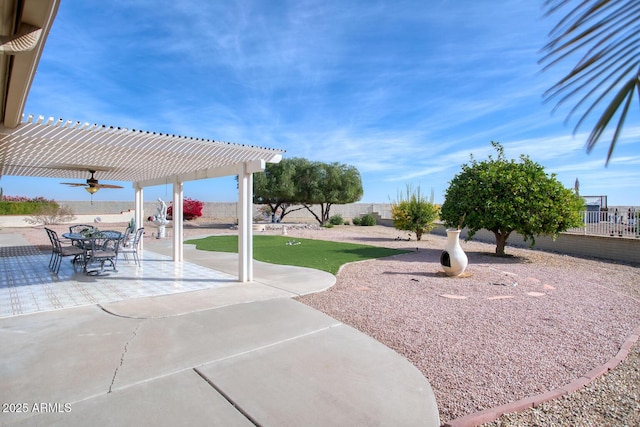 view of yard with ceiling fan, a pergola, and a patio area