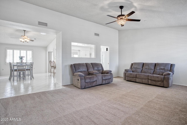 carpeted living room with ceiling fan, a textured ceiling, and vaulted ceiling