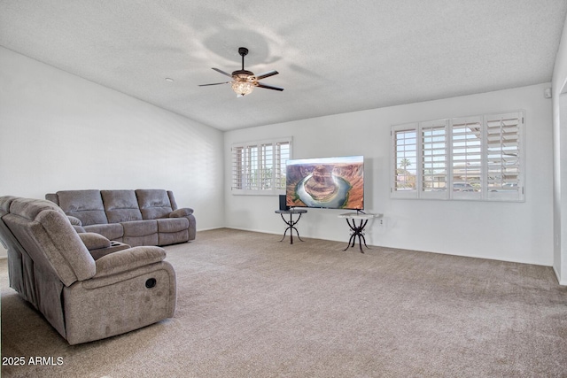 carpeted living room with ceiling fan and a textured ceiling