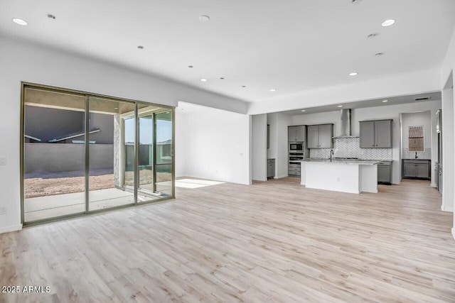 unfurnished living room featuring sink and light wood-type flooring